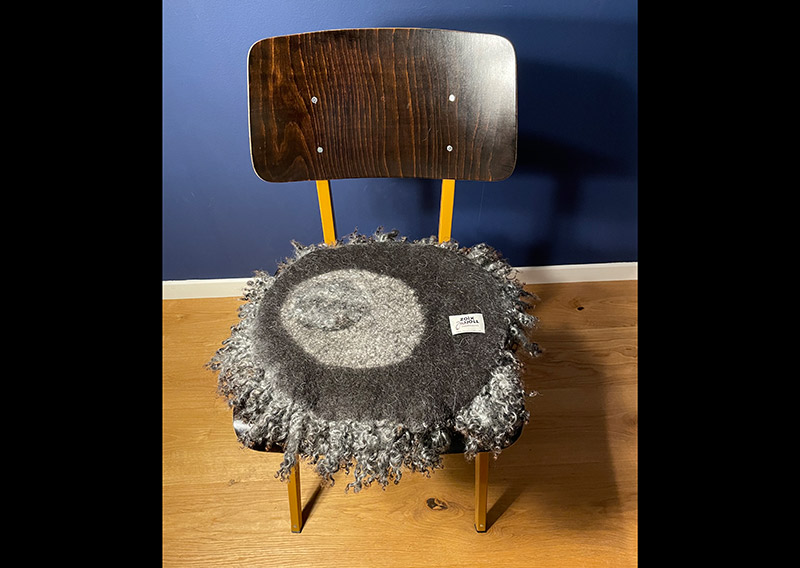 Ein Sitz- oder Dekokissen gefertigt mit den Lamm-Locken von Gotland-Pelzschafen. Die edle Wolle glänzt wie Seide, ist etwas schwerer und fühlt sich extrem fein und weich an. Für die Herstellung solcher Felle braucht es viel Handarbeit, da die Locken nicht zusammenhängend sind. Die Unikate schmücken richtig hygge den Wohnbereich und sind ein Magnet für Augen und Hände. 
Die Wolle lebt durch das benutzen des Sitzkissens mit und verändert sich. Es ist ein Gebrauchsgegenstand der einfach nur wohlige wollige wärme für Herz und Seele spendet. Meines Erachtens bleibt das Fell immer schön, auch wenn die Locken mit der Zeit Gebrauchsspuren haben – es ist einfach schön, wenn es gebraucht wird. Oder das Fell dient für eine stilvolle Dekoration, so bleiben die Locken wie sie sind – eine Augenweide. 
